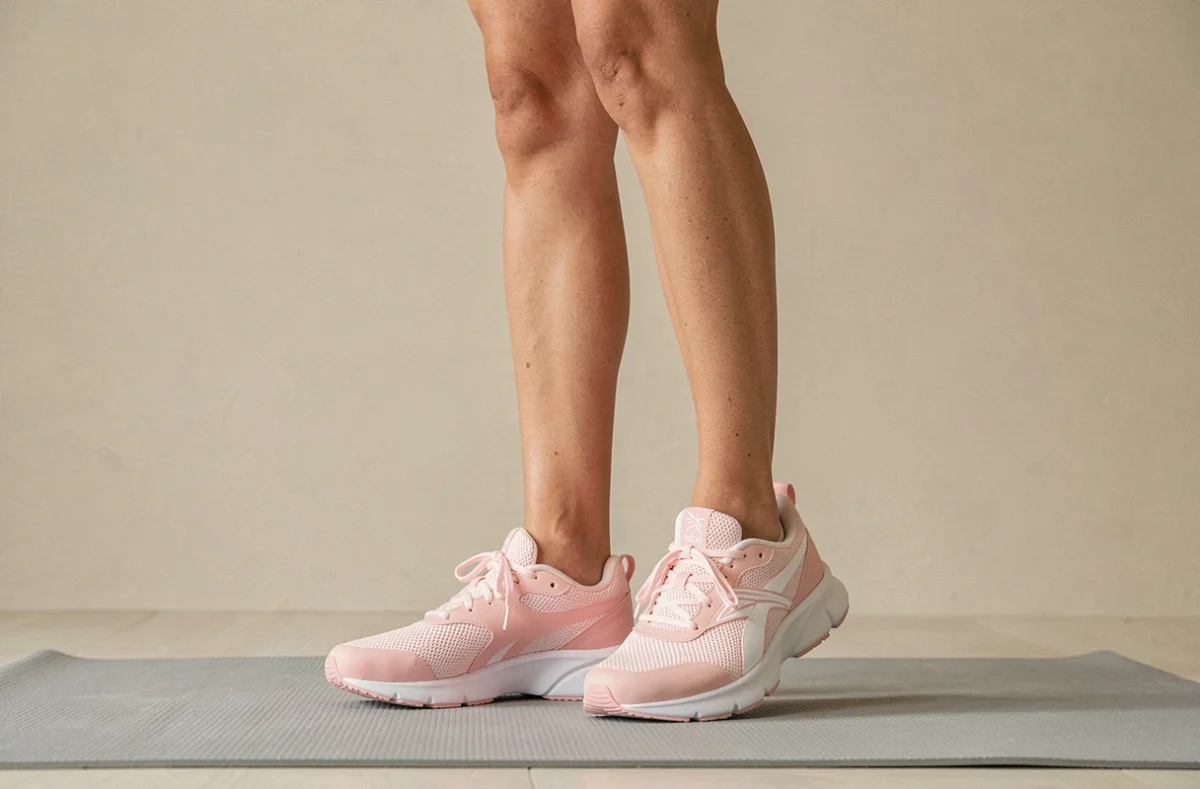 Baskets Reebok Nanoflex TR 3 femme portées lors d'une pose de yoga en studio, amorti souple pour le fitness général